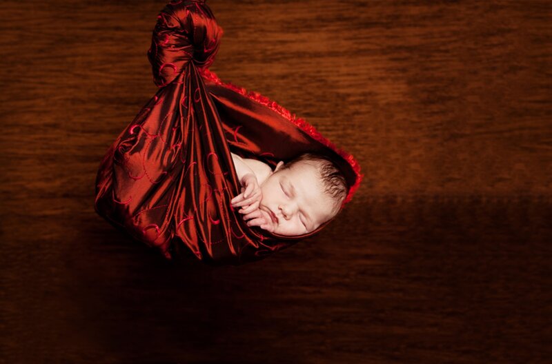 Newborn Baby in Red Wrap