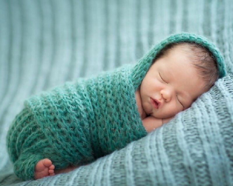Newborn baby sleeping wrapped in green