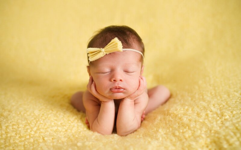 Newborn baby with yellow bow