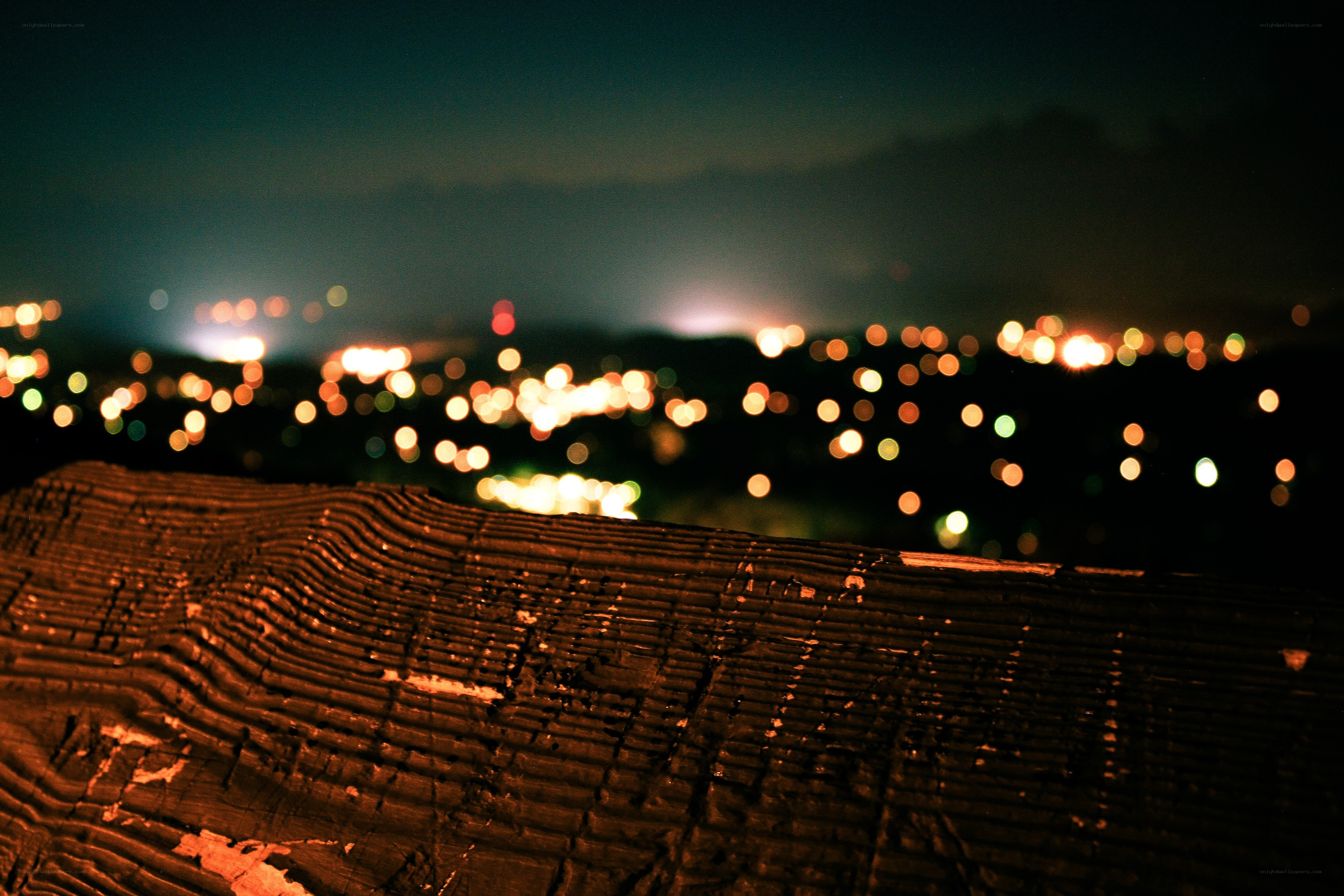 Night city lights from wooden bench