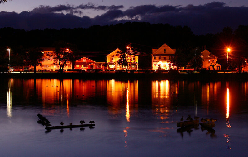 Night lights reflect on a calm lake