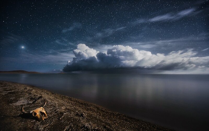 Night sky over a lake with skull