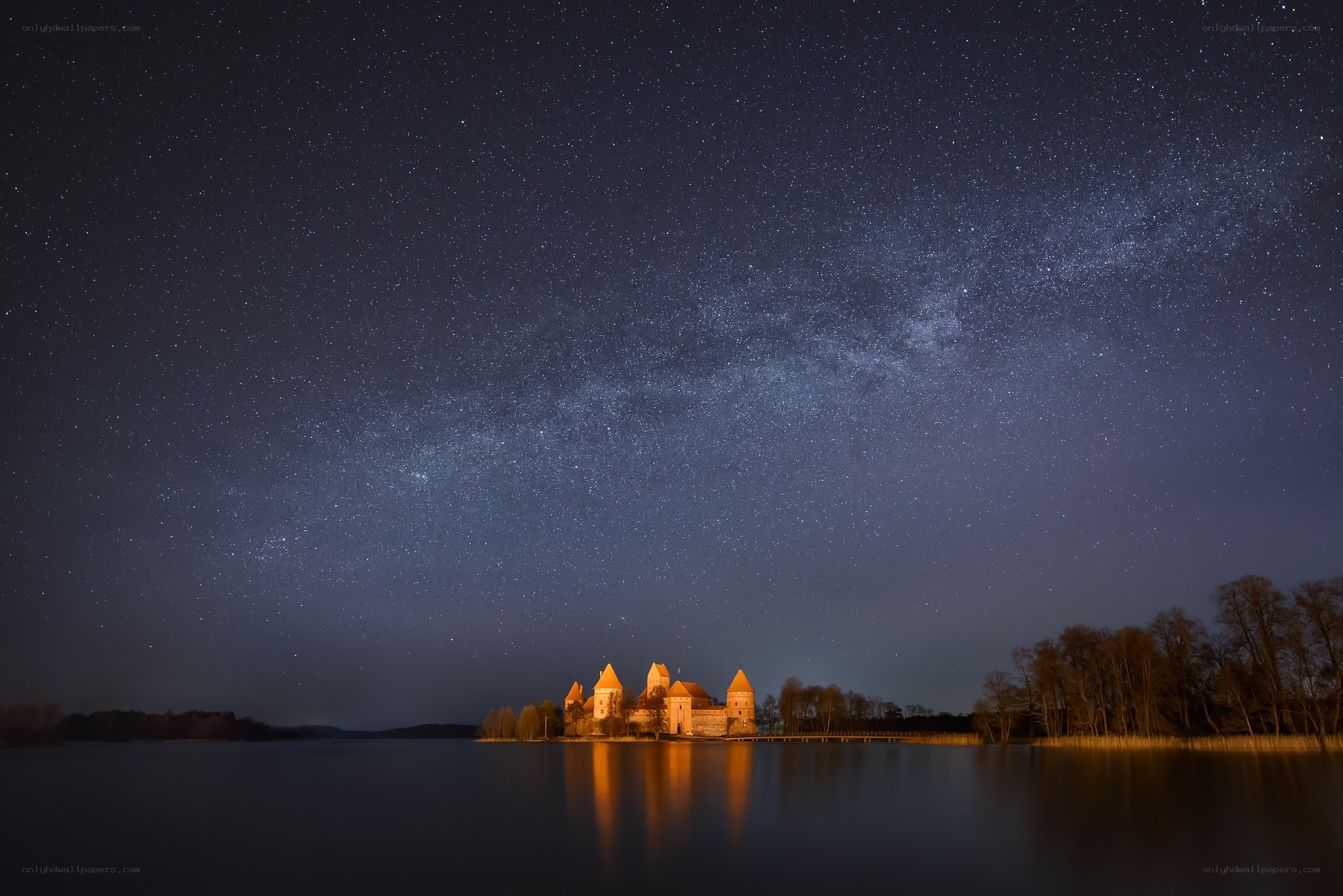 Night sky over castle on lake