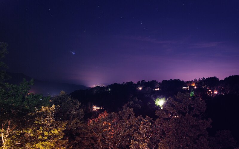 night sky over forested hills