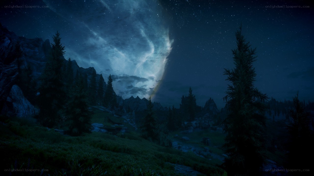 Night sky over forested mountains
