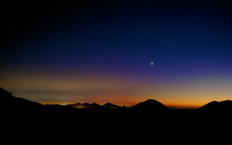 Night sky over silhouetted mountains