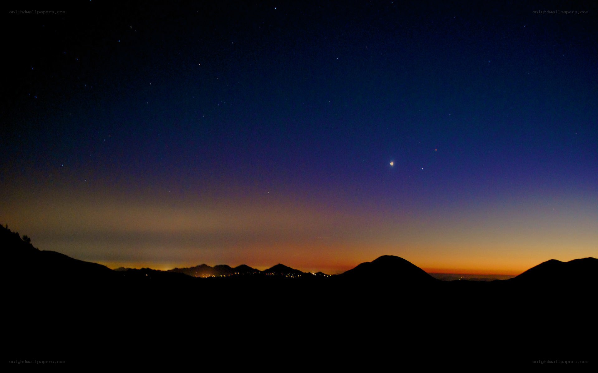 Night sky over silhouetted mountains