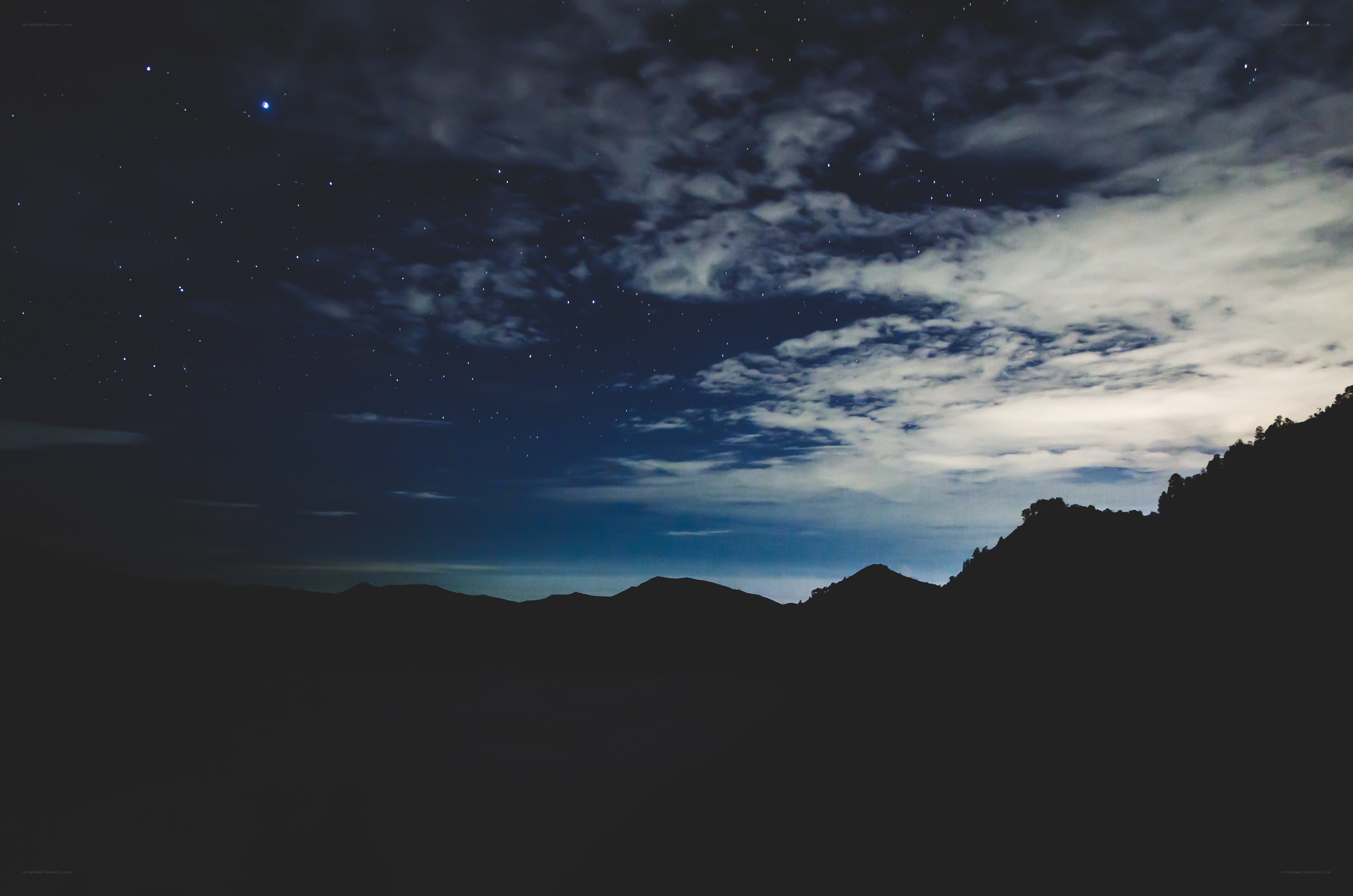 Night sky over silhouetted mountains