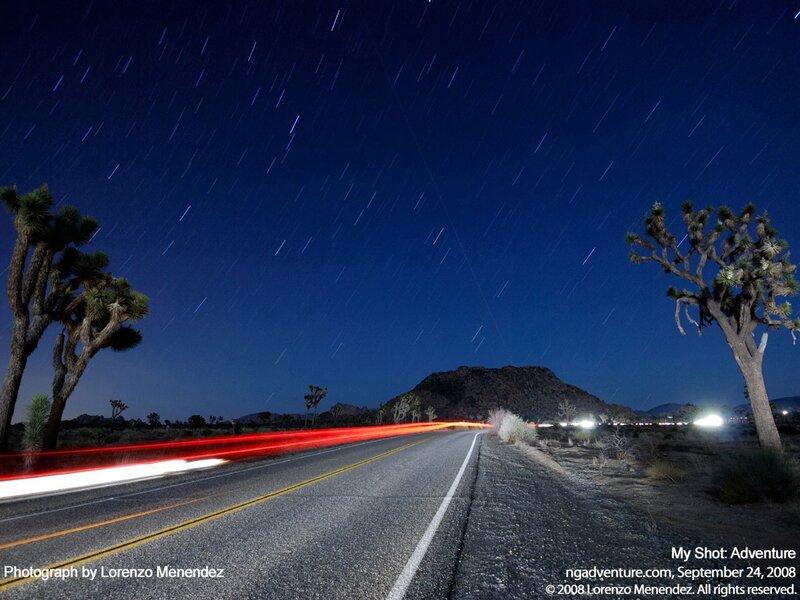 Night sky with star trails and road