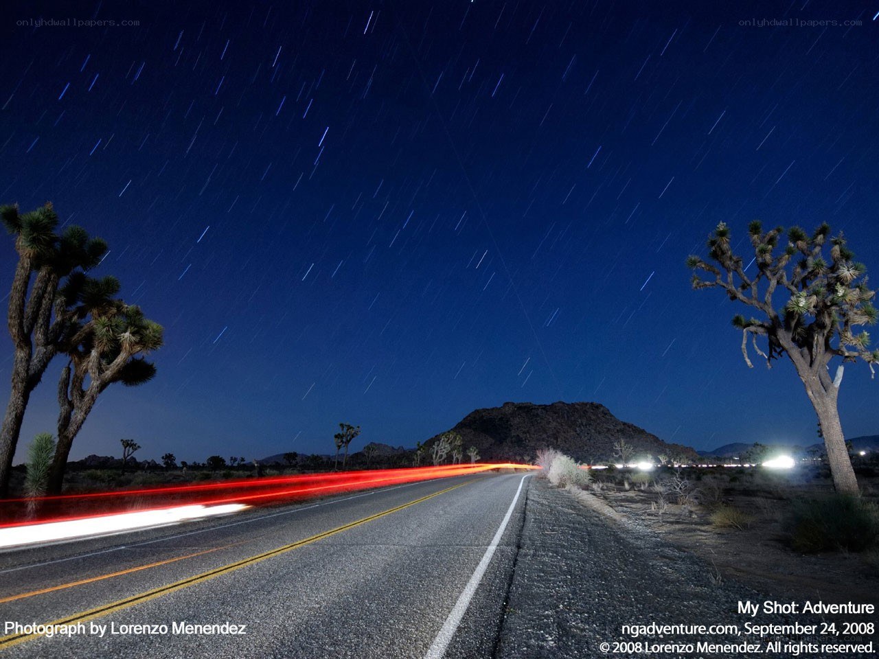 Night sky with star trails and road