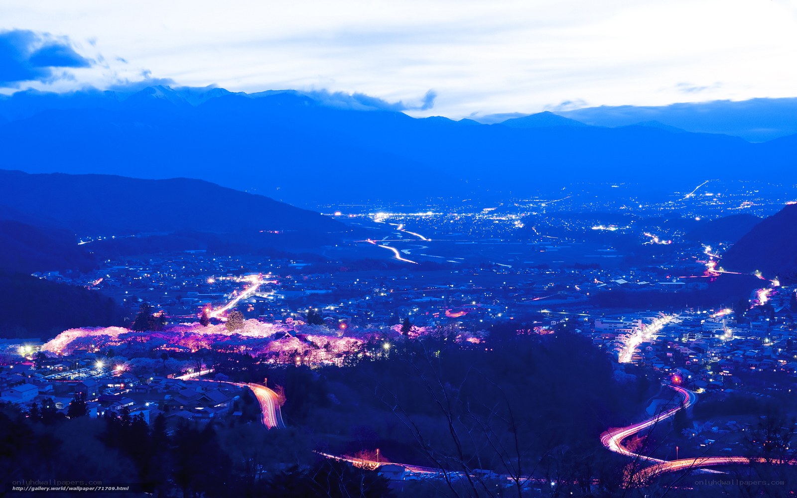 night view of a city with mountains