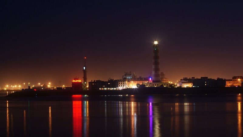 night view of lighthouse and city