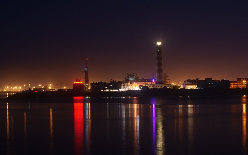 night view of lighthouse and harbor