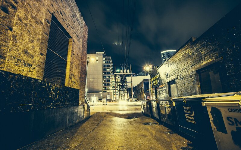 nighttime alleyway with dumpsters