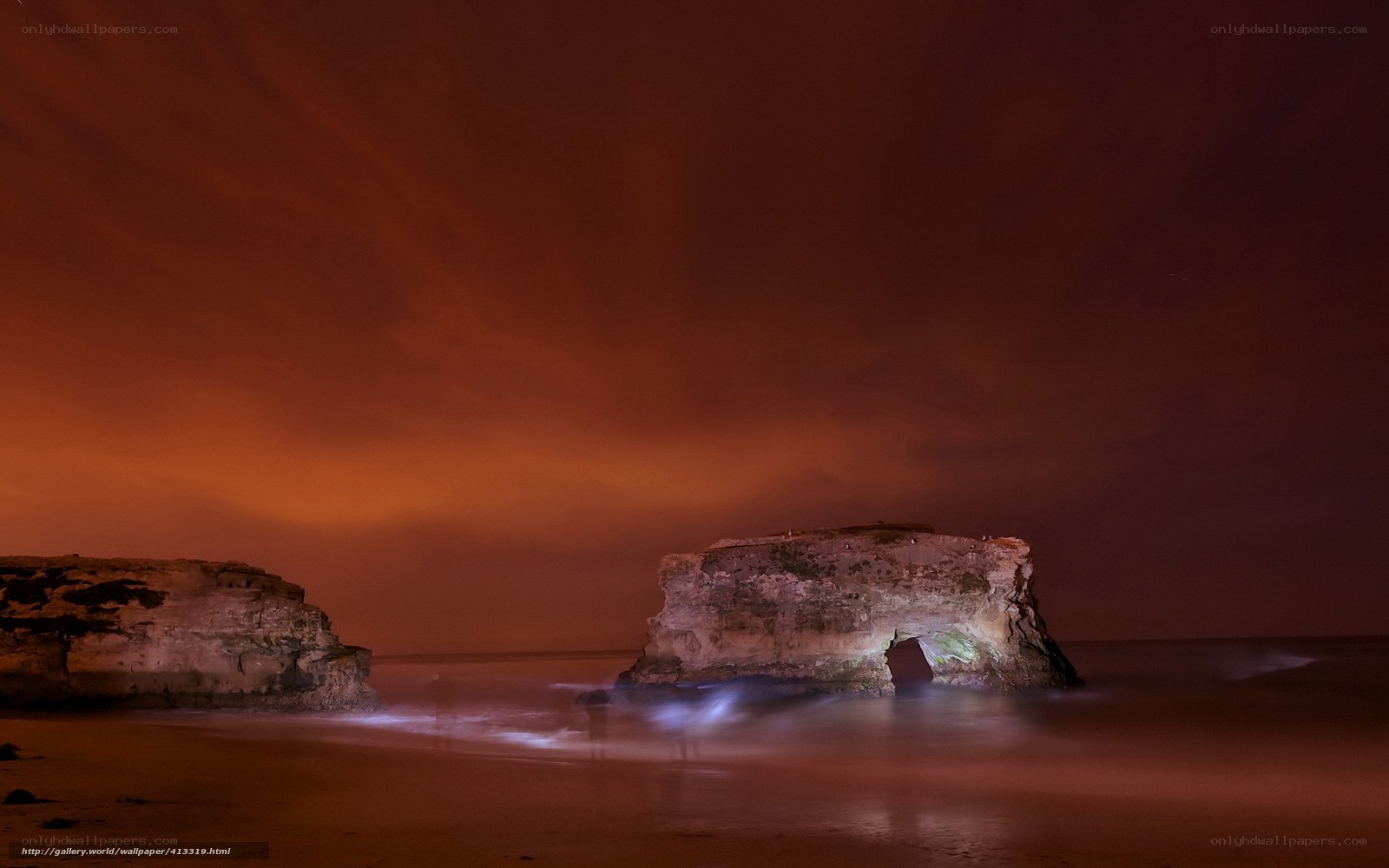 Nighttime beach with rock arch