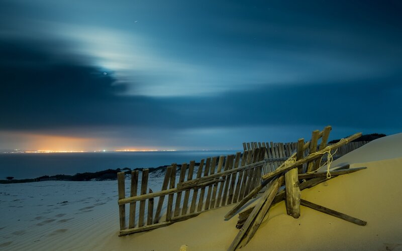 Nighttime beach with wooden fence