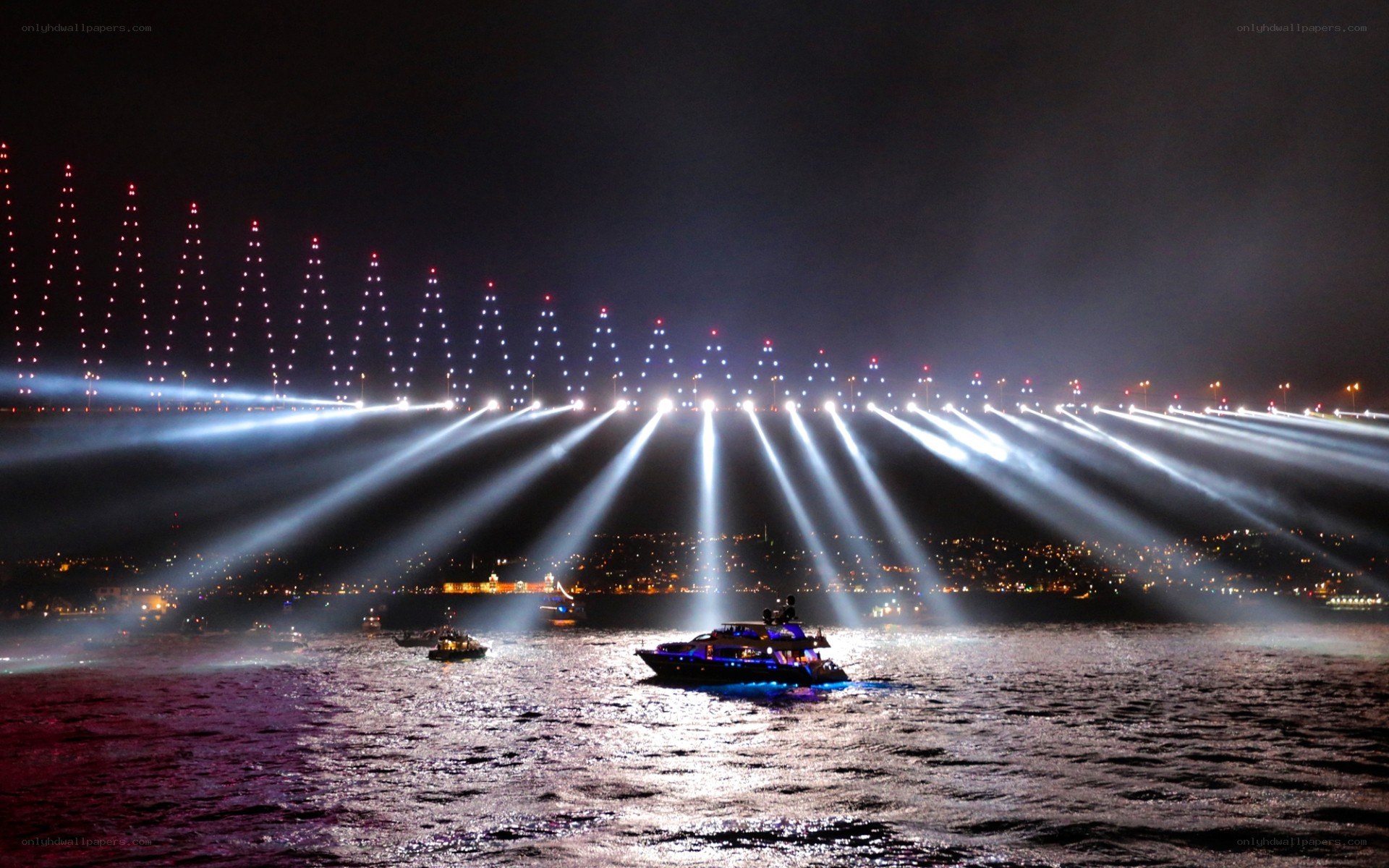 Nighttime boat parade with bridge lights