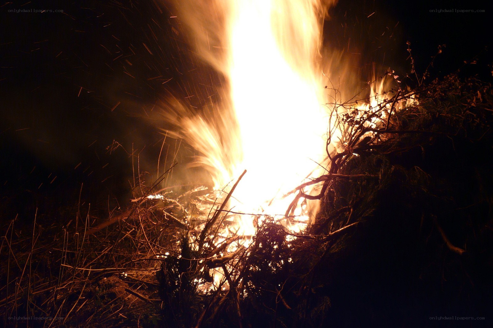 Nighttime bonfire with sparks