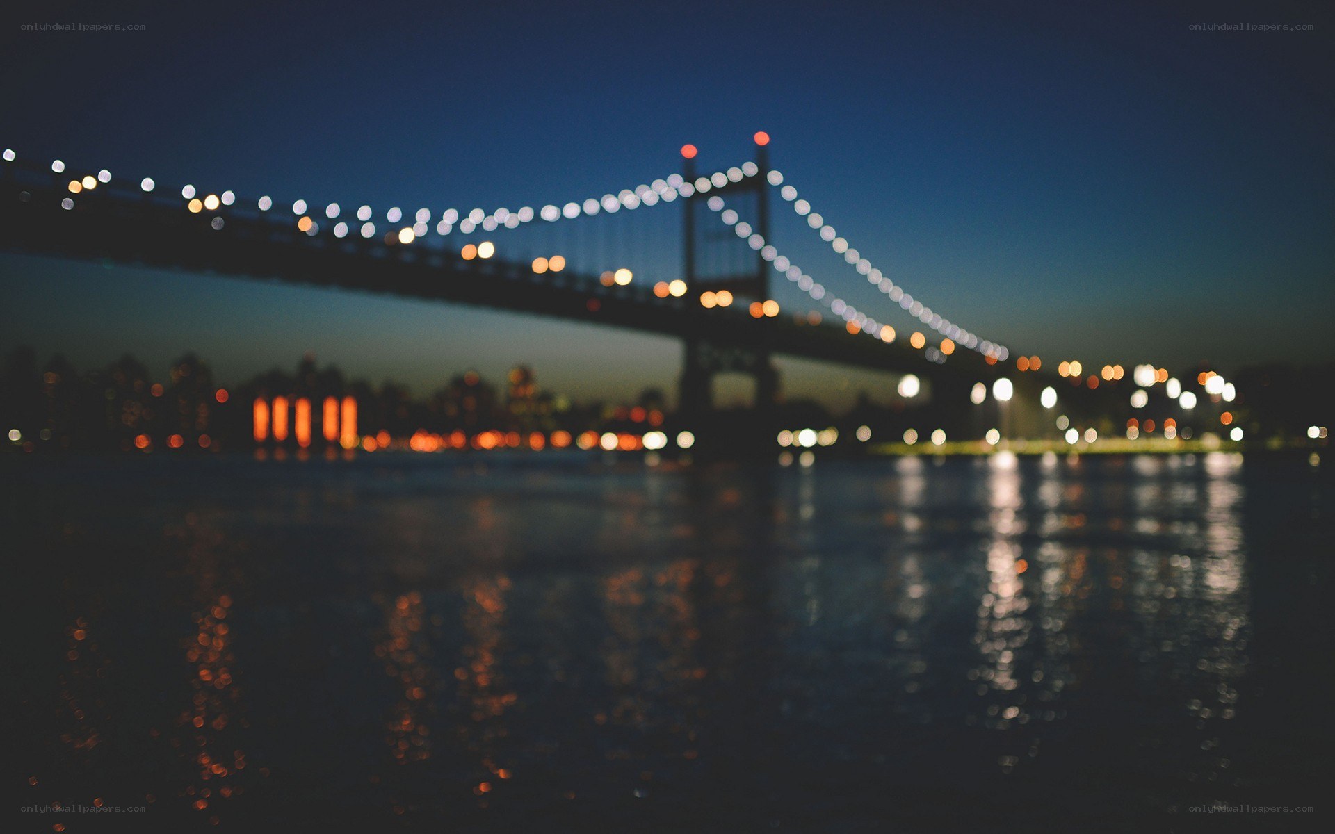 nighttime bridge with city lights