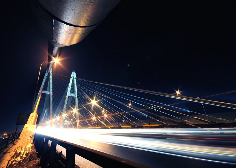Nighttime bridge with light trails