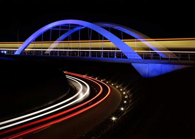 Nighttime bridge with light trails