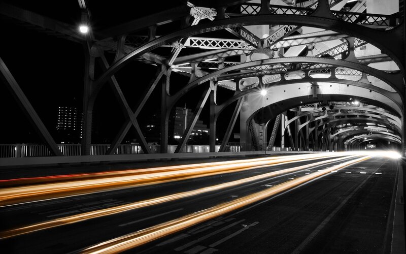 Nighttime bridge with light trails