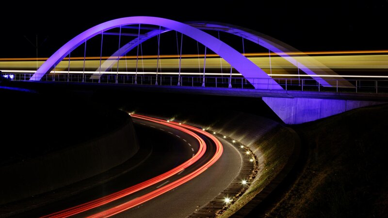 Nighttime bridge with light trails