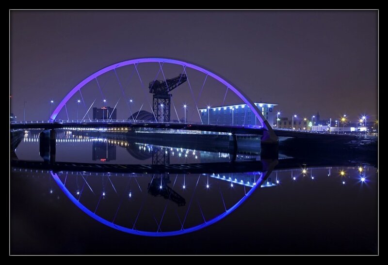 nighttime bridge with purple lights