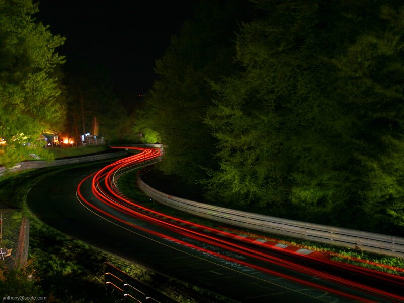 Nighttime car lights on a winding road