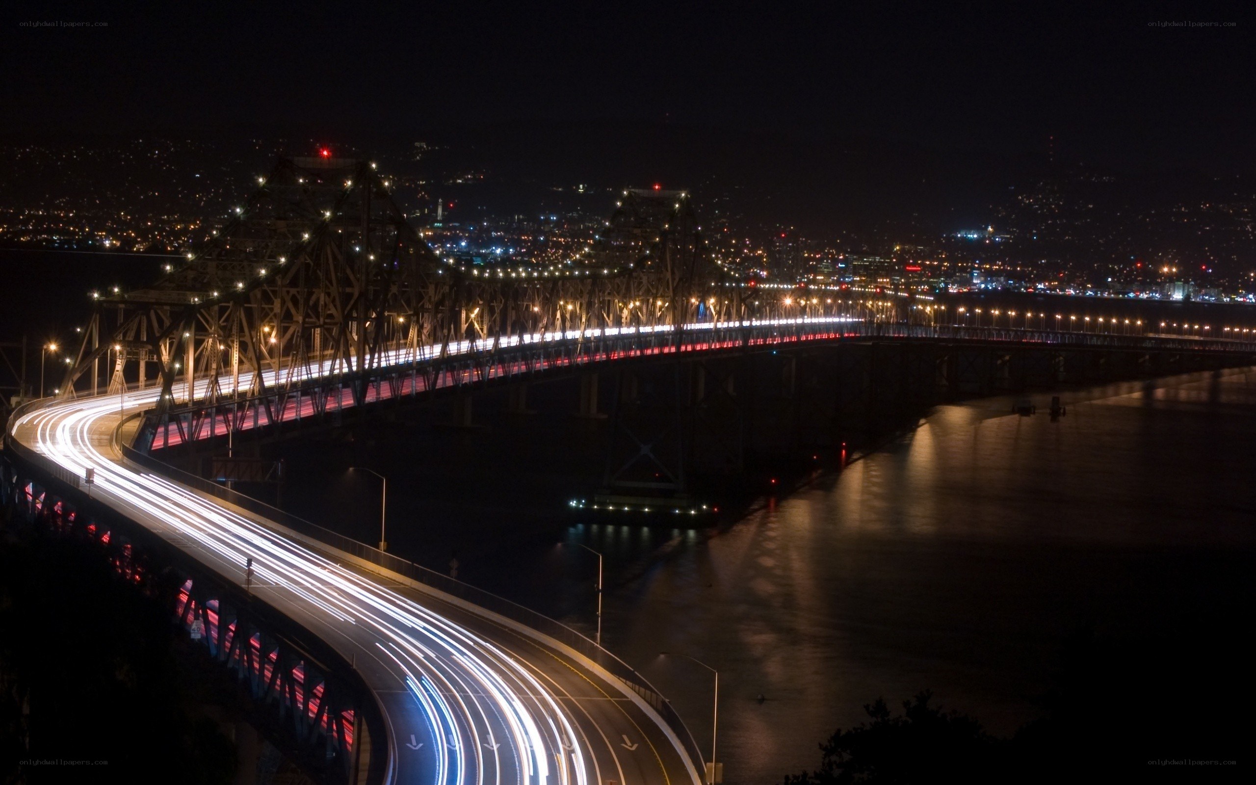 Nighttime city bridge with light trails