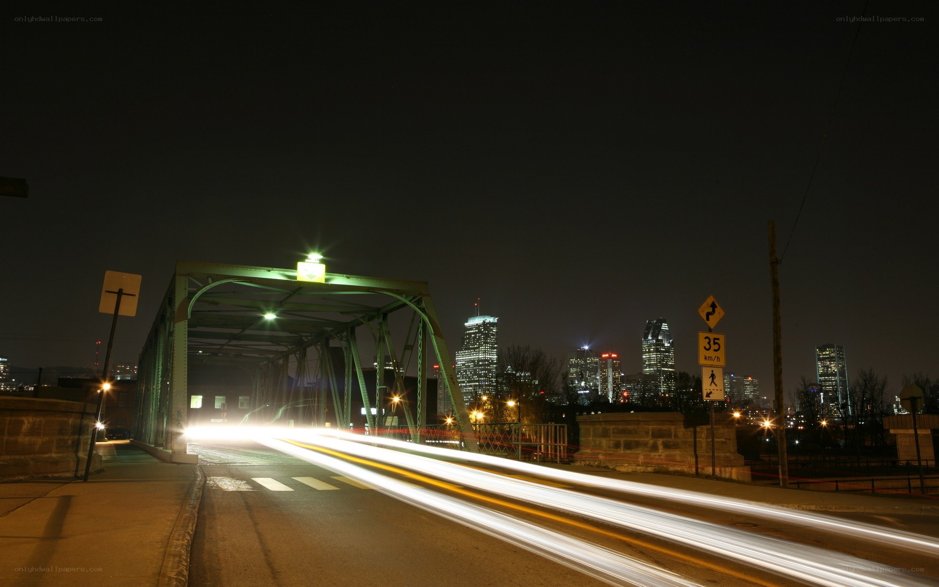 Nighttime city bridge with light trails