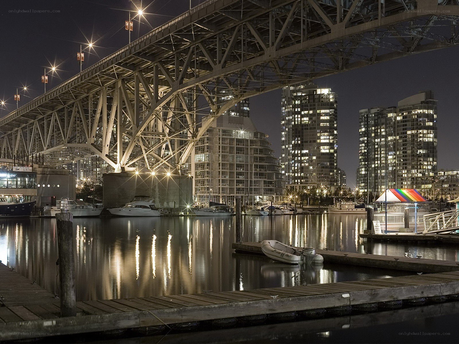 Nighttime city harbor under bridge