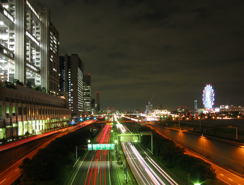 nighttime city highway with ferris wheel