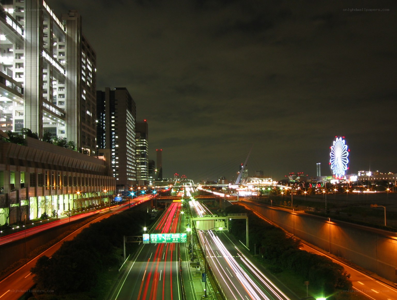 nighttime city highway with ferris wheel