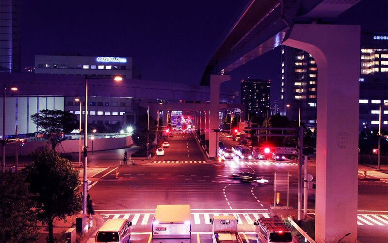 nighttime city intersection with elevated train