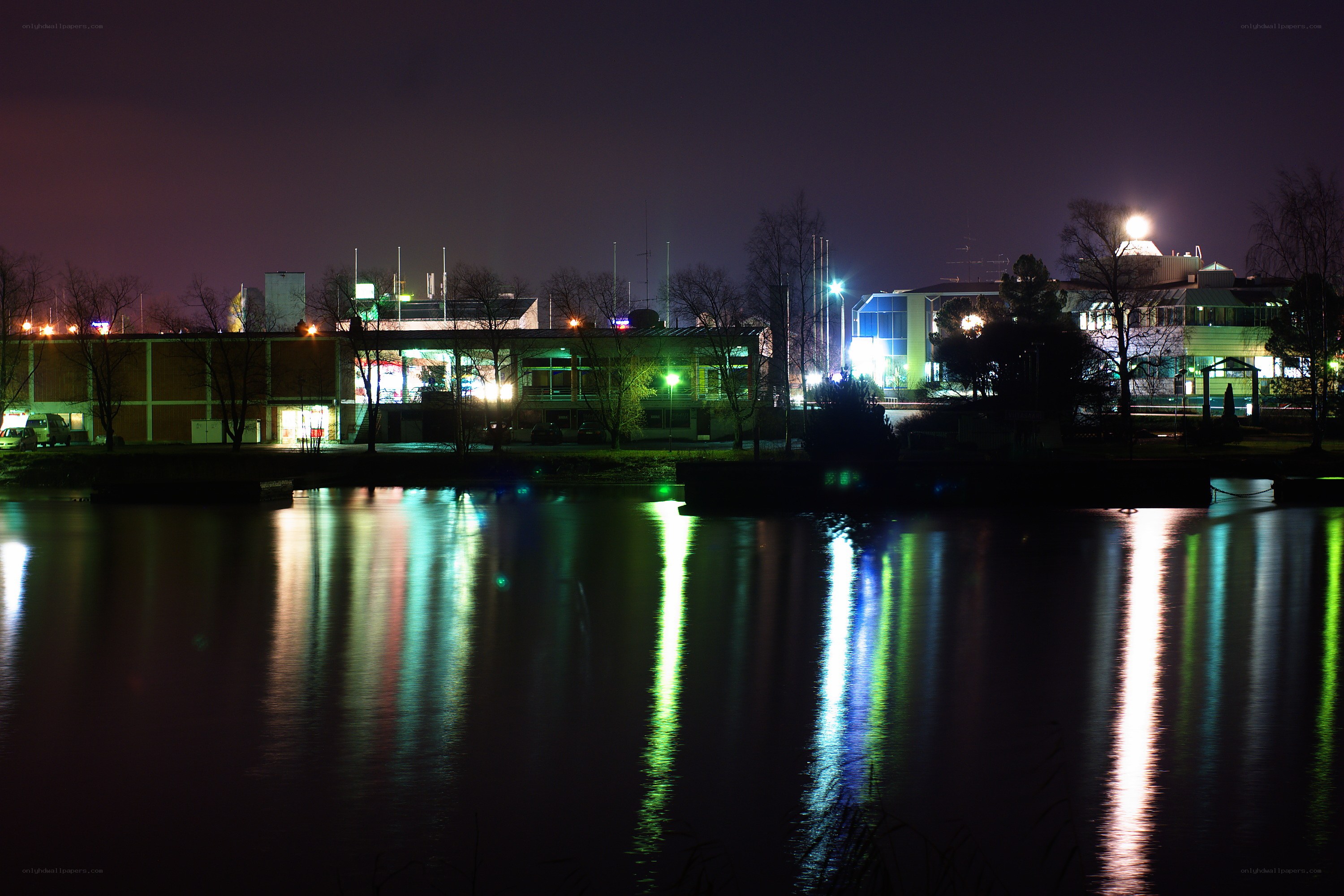 nighttime city lights reflected in water