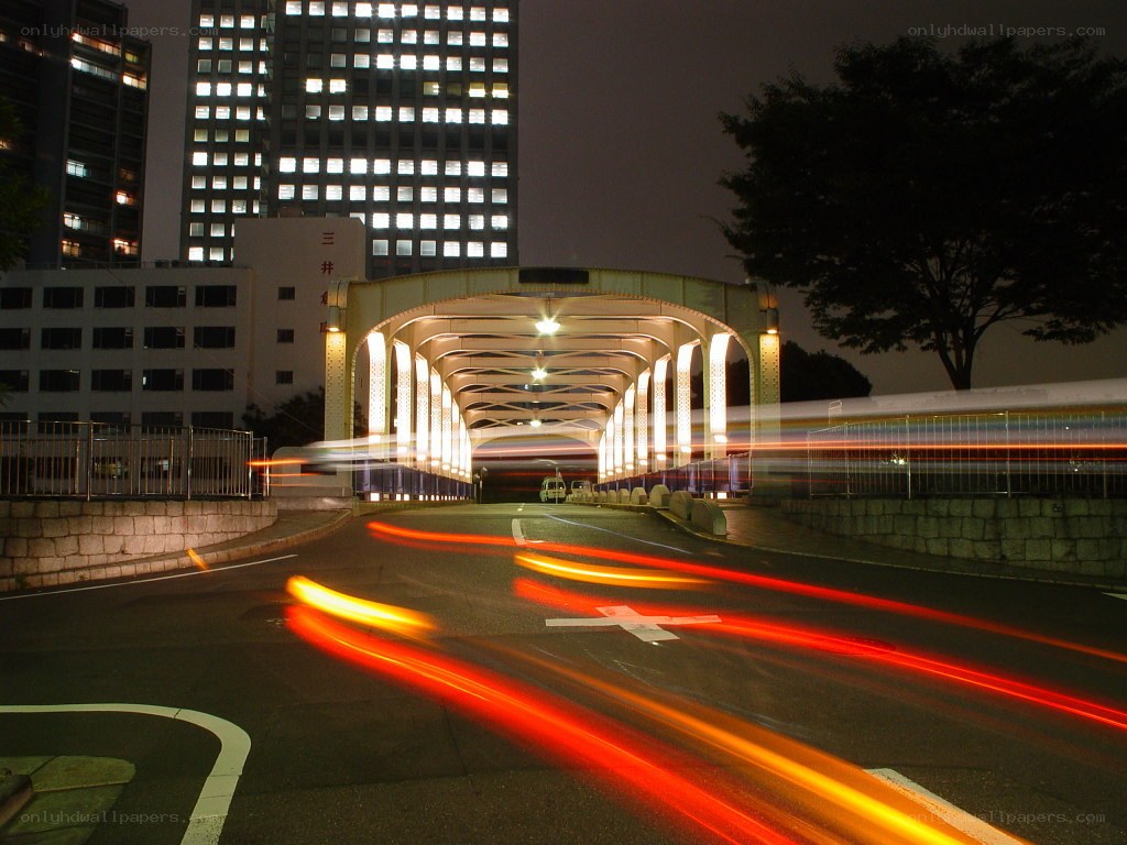 Nighttime city lights under a bridge