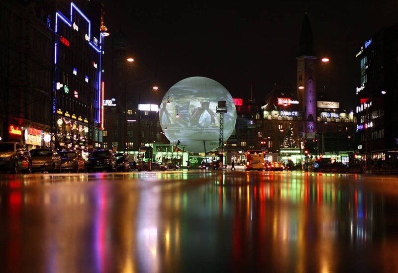 Nighttime city scene with large sphere