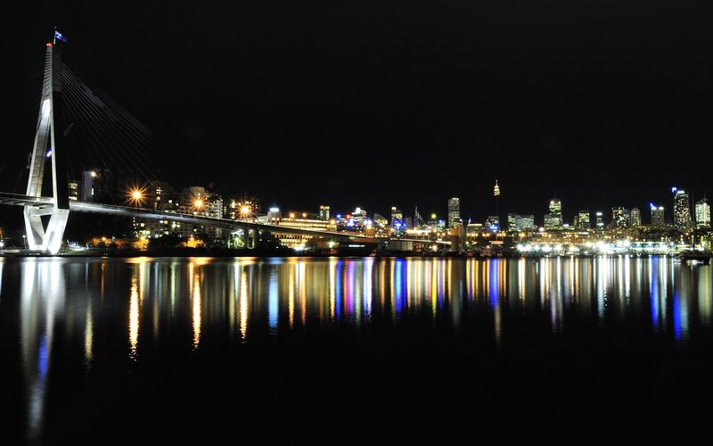 nighttime city skyline with bridge