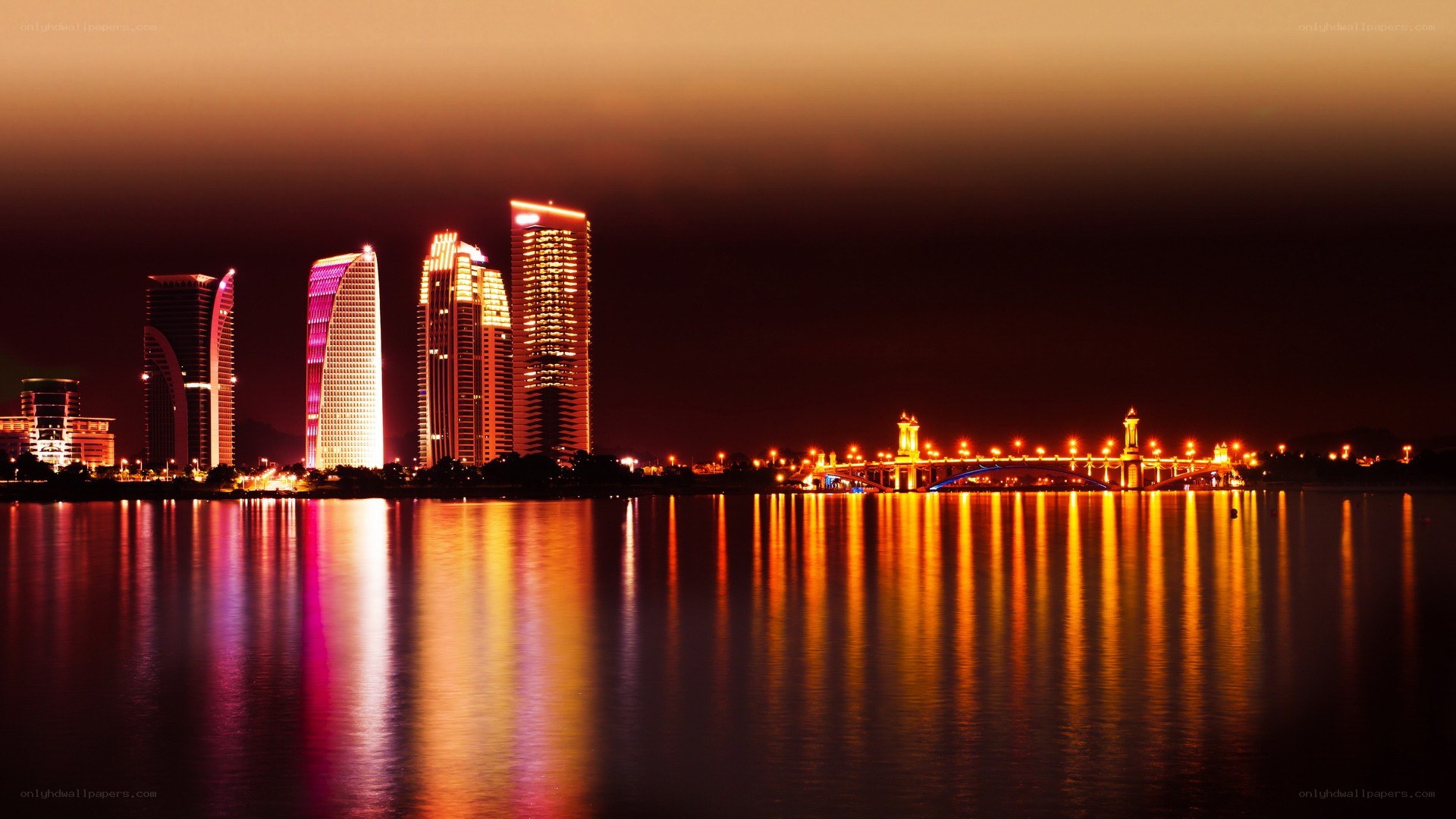 nighttime city skyline with bridge