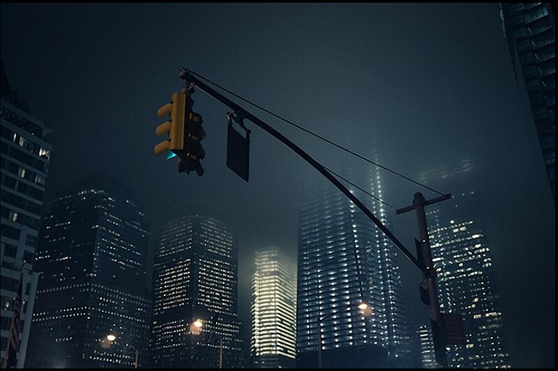 nighttime city skyline with traffic light