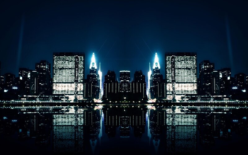nighttime city skyline with water reflection