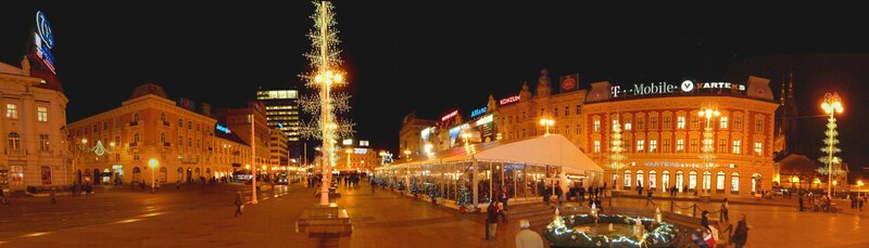 nighttime city square with christmas lights