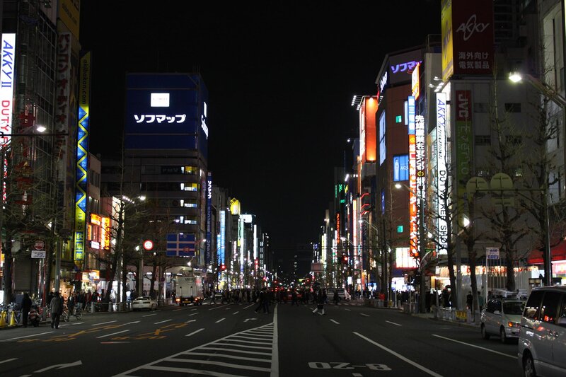 nighttime city street with neon signs