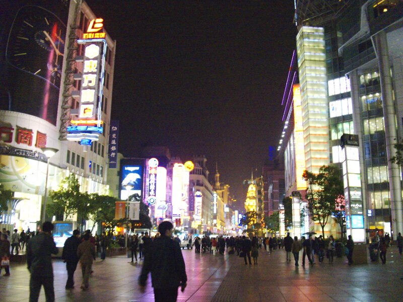 nighttime city street with neon signs