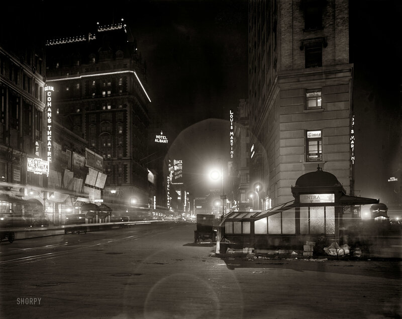 Nighttime city street with neon signs