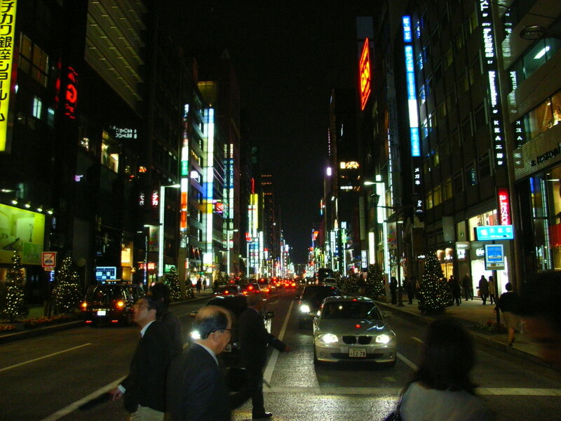 nighttime city street with neon signs