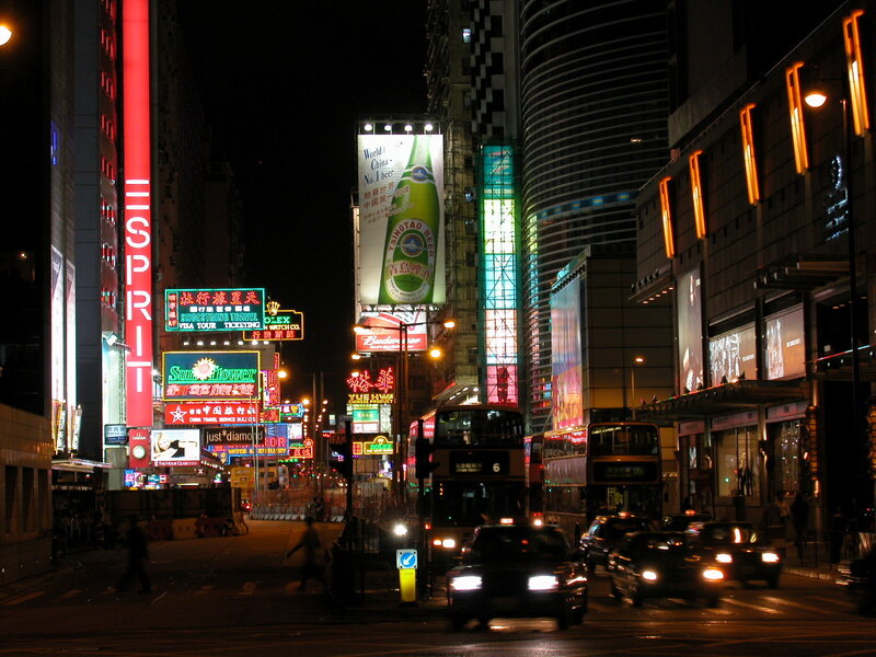 Nighttime city street with neon signs