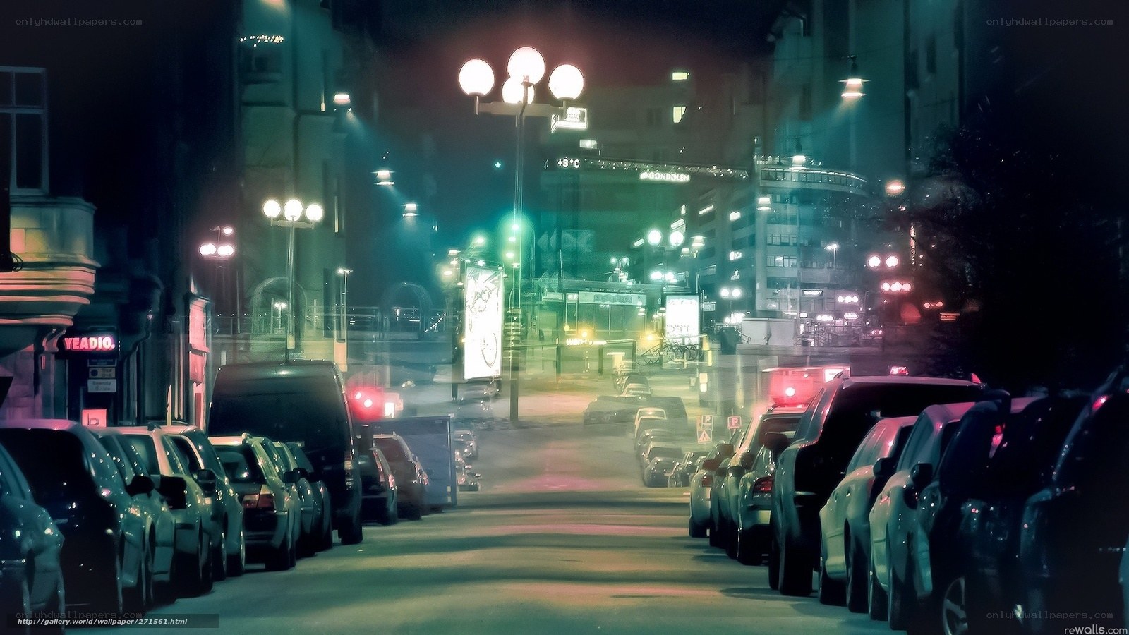 Nighttime city street with parked cars