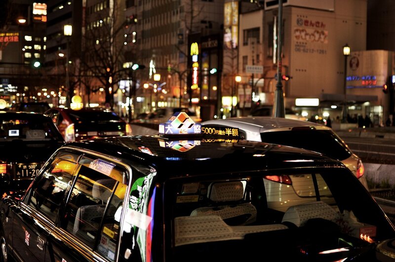 Nighttime city street with taxi
